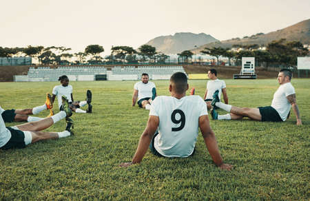 The training session has begun. Cropped shot of a group of young rugby players training on the field during the day.の写真素材