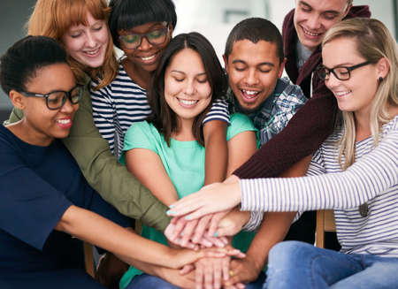 Huddled around happiness. Shot of a group of people putting their hands together.の写真素材