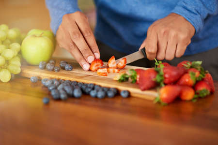 Cutting calories out of his diet. Cropped shot of a man preparing a healthy and fruity snack.の写真素材