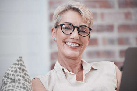 What is joyful, what is true. Portrait on an older woman using a laptop and looking relaxed on the...