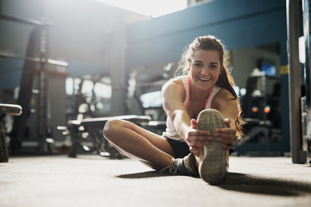 Every workout is progress. Shot of a young woman doing stretch exercises at the gym.