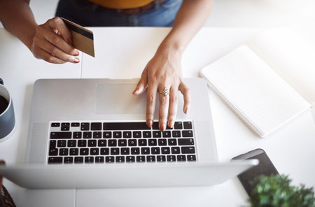 Thanks to technology, shopping has never been this easy. High angle shot of an unrecognizable female designer shopping online in her home office.の写真素材