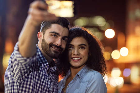 Memories are made of this. Shot of an affectionate young couple taking a selfie while out on a date in the city.の写真素材