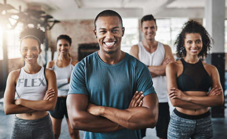 Were here for the fitness. Portrait of a group of confident young people working out together in a gym.の写真素材