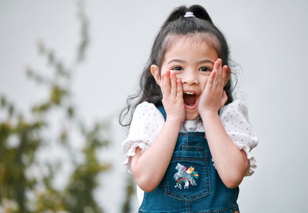 I love surprises. Shot of an adorable little girl looking surprised while standing outside.の写真素材