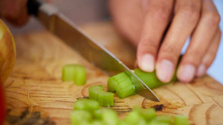 The base of every soup. Shot of a woman chopping up celery.