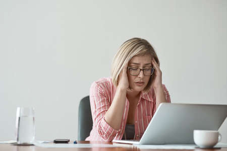 These deadlines are giving me a headache. Studio shot of a businesswoman looking stressed out while...