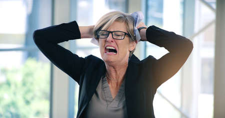 I dont see an end to this challenge. Shot of a mature businesswoman looking stressed out in an office.の写真素材