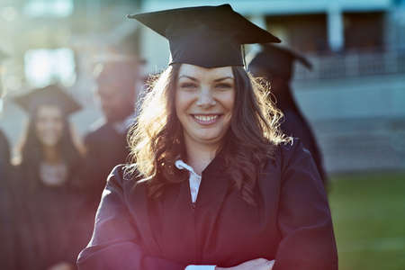 Im ready to take on the world now. Portrait of a young student on graduation day.の写真素材