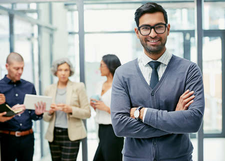 Youre only as good as the team behind you. Portrait of a businessman standing in an office with his...