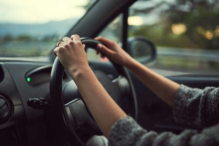 Hands on the steering wheel. Cropped shot of an unrecognizable woman driving her car.の写真素材