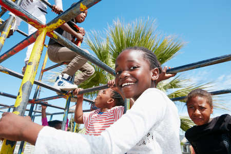 The world is their playground. Portrait of a happy little girl playing on a jungle gym.の写真素材