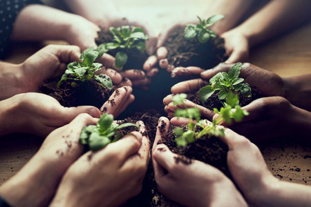 Growing a greener tomorrow together. Closeup shot of a group of people each holding a plant growing in soil.の写真素材