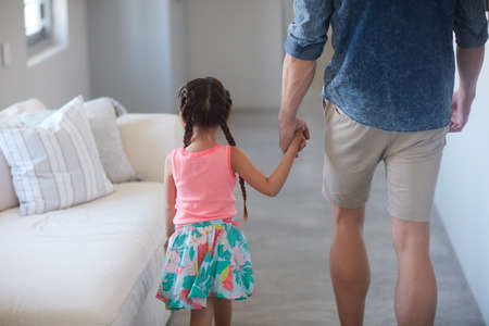 She wants to go everywhere dad goes. Shot of a father and daughter spending time together at home.の写真素材
