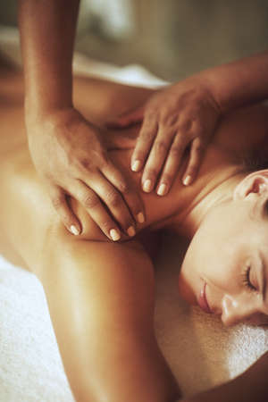 It doesnt get anymore relaxing.... Shot of a young woman enjoying a back massage.の写真素材