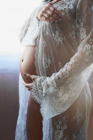 Theres nothing quite like a mothers love. Cropped shot of an unrecognizable pregnant woman standing in her bedroom at home.の写真素材