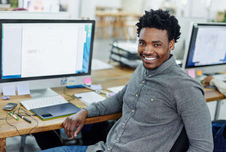 Turning a passion for design into a career. Portrait of an smiling young designer sitting at a...