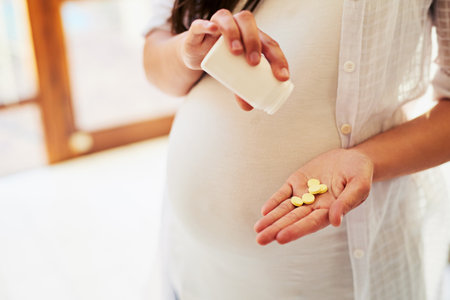 Healthy supplements to help my baby grow. Cropped shot of an unrecognizable pregnant woman taking medication at home.の写真素材