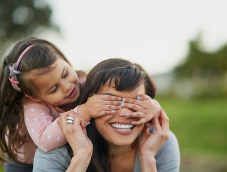Guess who. Cropped shot of a mother and daughter enjoying some quality time together outdoors.の写真素材