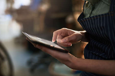 Letting technology take care of the details. Shot of a young female designer in her workshop.の写真素材
