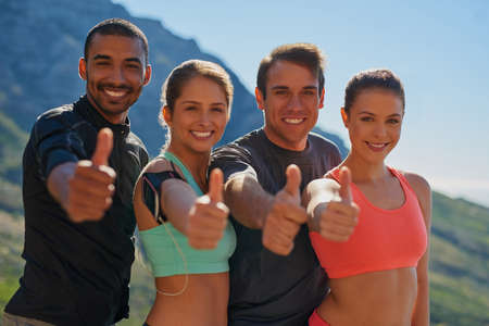 Its just better to exercise in groups. Cropped shot of a fitness group showing thumbs up.の写真素材
