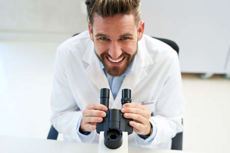 Clinical trials are an essential part of advancing medical science. Portrait of a male scientist using a microscope in a lab.の写真素材
