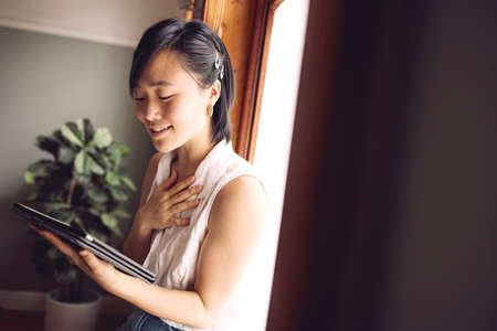 This is the kindest email Ive ever received. Shot of a young woman reading her tablet with a happy...