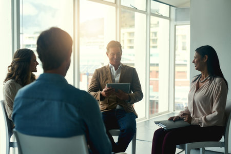 Putting brilliance to work. Shot of a group of happy coworkers having a meeting in a huddle in the office.の写真素材