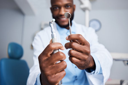 One beautifully bright smile coming right up. Portrait of a young man holding teeth cleaning tools in his dentists office.の写真素材
