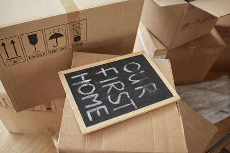 Its our first home. Shot of a blackboard with the words OUR FIRST HOME on it.