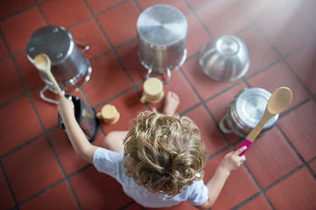 Showing off his drumming skills. High angle shot of an adorable little boy playing drums on a set of...