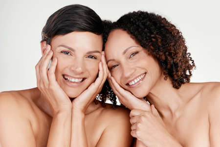 This skincare regime is working for us. Cropped portrait of two beautiful mature women posing against a grey background in studio.の写真素材