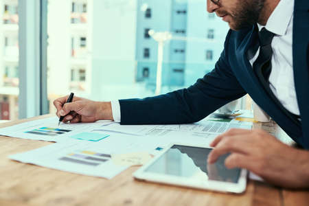 Getting down to business. Shot of an unidentifiable businessman working in an office.