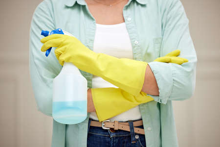 Armed to the teeth and ready for battle. Shot of a woman holding a spray bottle about to clean.の写真素材