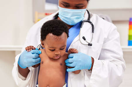 Shes a strong little one. Shot of a young female doctor doing a checkup on a baby at a clinic.の写真素材