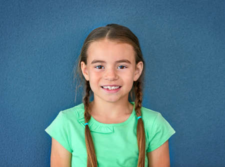 Happy being me. Studio shot of an adorable little girl posing against a blue background.の写真素材