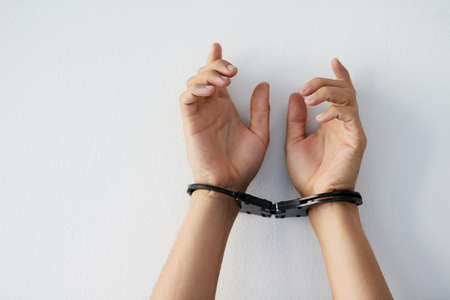 Prisoner of ones brain. Cropped shot of a unrecognizable persons hands that are cuffed against a grey background.の写真素材