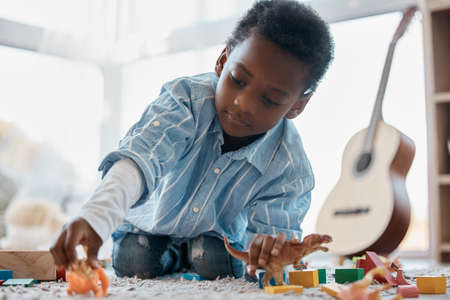 Give a boy a dinosaur and hell he entertained for ages. Shot of an adorable little boy playing with his toys in his bedroom.の写真素材