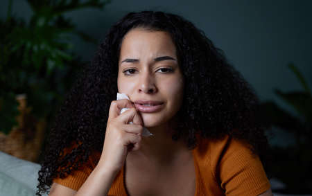 I need help. Shot of a young woman feeling unhappy at home.の写真素材