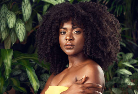 Good for the environment, great for the skin. Shot of a beautiful young woman posing against a leafy background.の写真素材