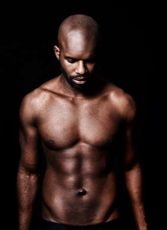 In a league of his own. Cropped shot of a calm muscular man isolated on black.の写真素材