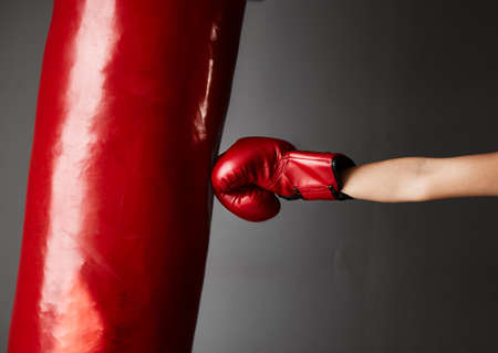Strike hard and strike fast. Cropped shot of an unrecognizable young female boxer training in the gym.の写真素材