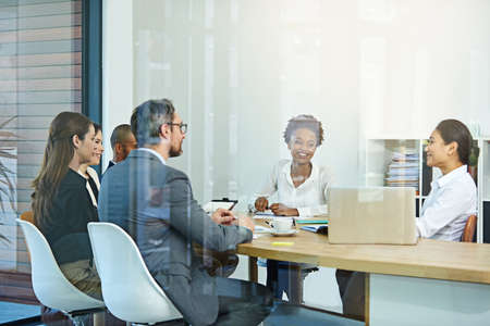 Open lines of communication. Cropped shot of a group of businesspeople meeting in the boardroom.の写真素材