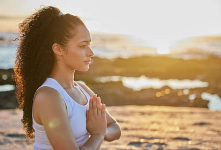 Free your mind. Cropped shot of an attractive young woman meditating on the beach.の写真素材