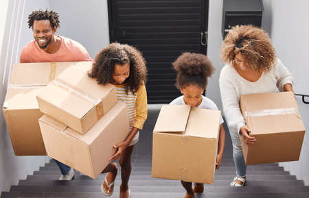 Theres nothing more important than a good, safe, secure home. Shot of a family carrying boxes into their new home.の写真素材