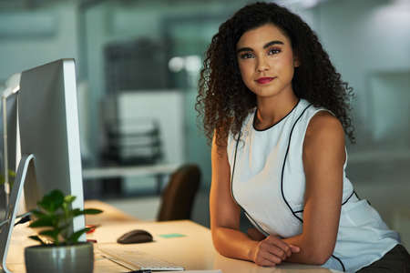 Ive got my career in focus. Portrait of a confident young businesswoman working at her desk at night.の写真素材