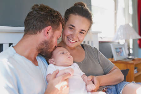 Our family, created by love. Shot of a young mother and father bonding with their newborn baby boy in the bedroom.の写真素材