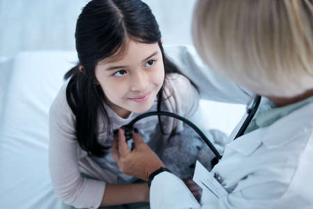 Happy and healthy. Shot of a little girl getting a checkup at the clinic.