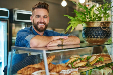 Look no further for fresh and affordable meals. Portrait of a proud business owner working in his store.の写真素材