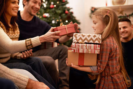 An abundance of gifts. Shot of a a family giving presents at christmas.の写真素材